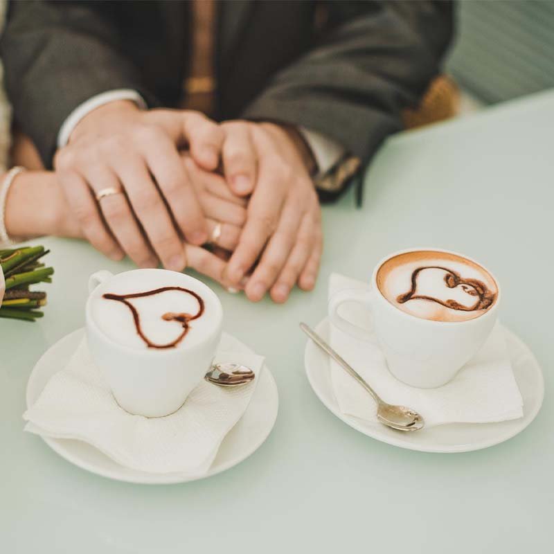 דוכן קפה לחתונות - זוג מחזיק ידיים עם טבעות נישואין