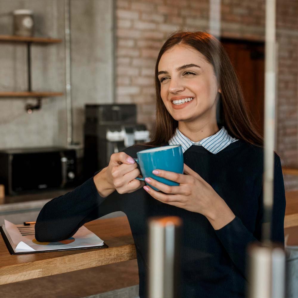 דוכן קפה האפי האוור אישה אוחזת בקפה ומחייכת