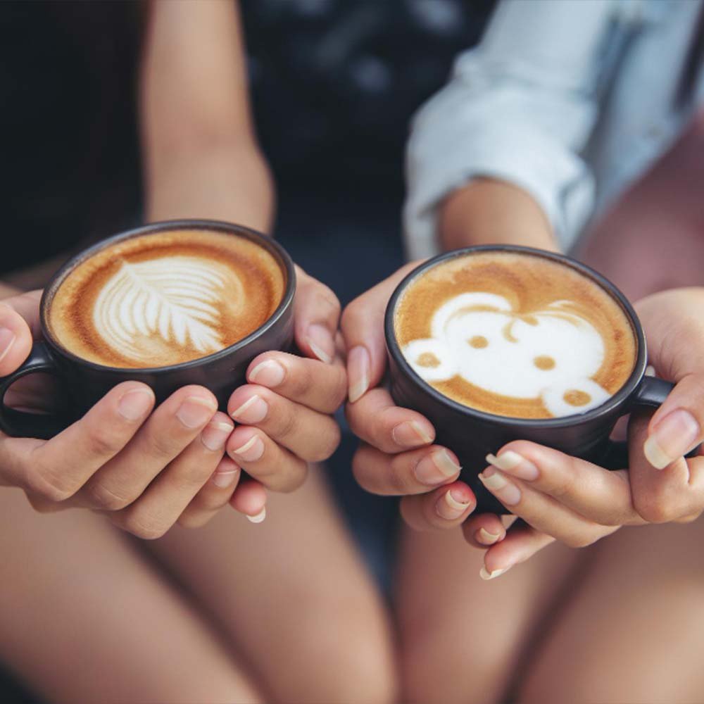 זוג בנות מחזיקות כוס קפה בכנס לעסקים