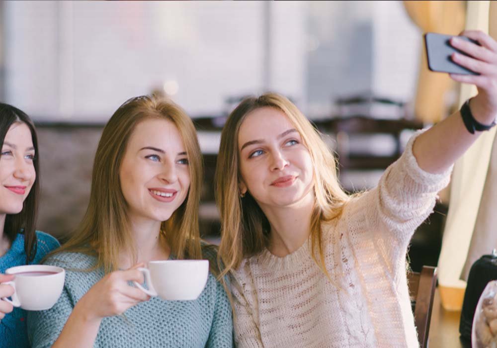 שלישיית נשים עושות ספלי עם כוס קפה