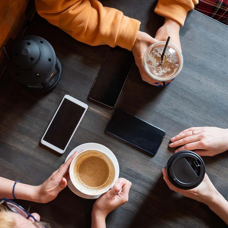 דוכן קפה לאירועים ברעננה חברים יושבים על שולחן שותים קפה